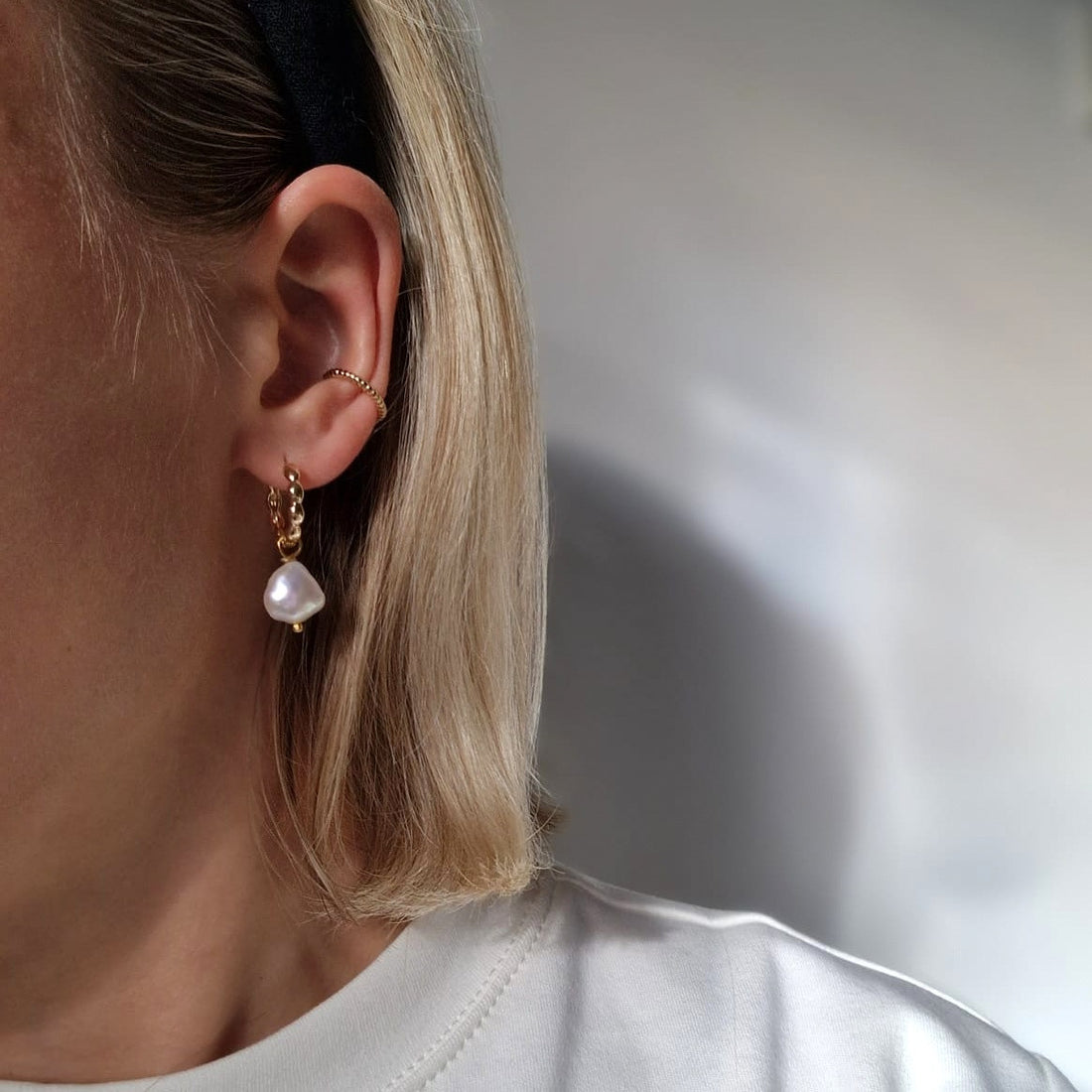 Die Smilla Creole in gold getragen am Ohr.