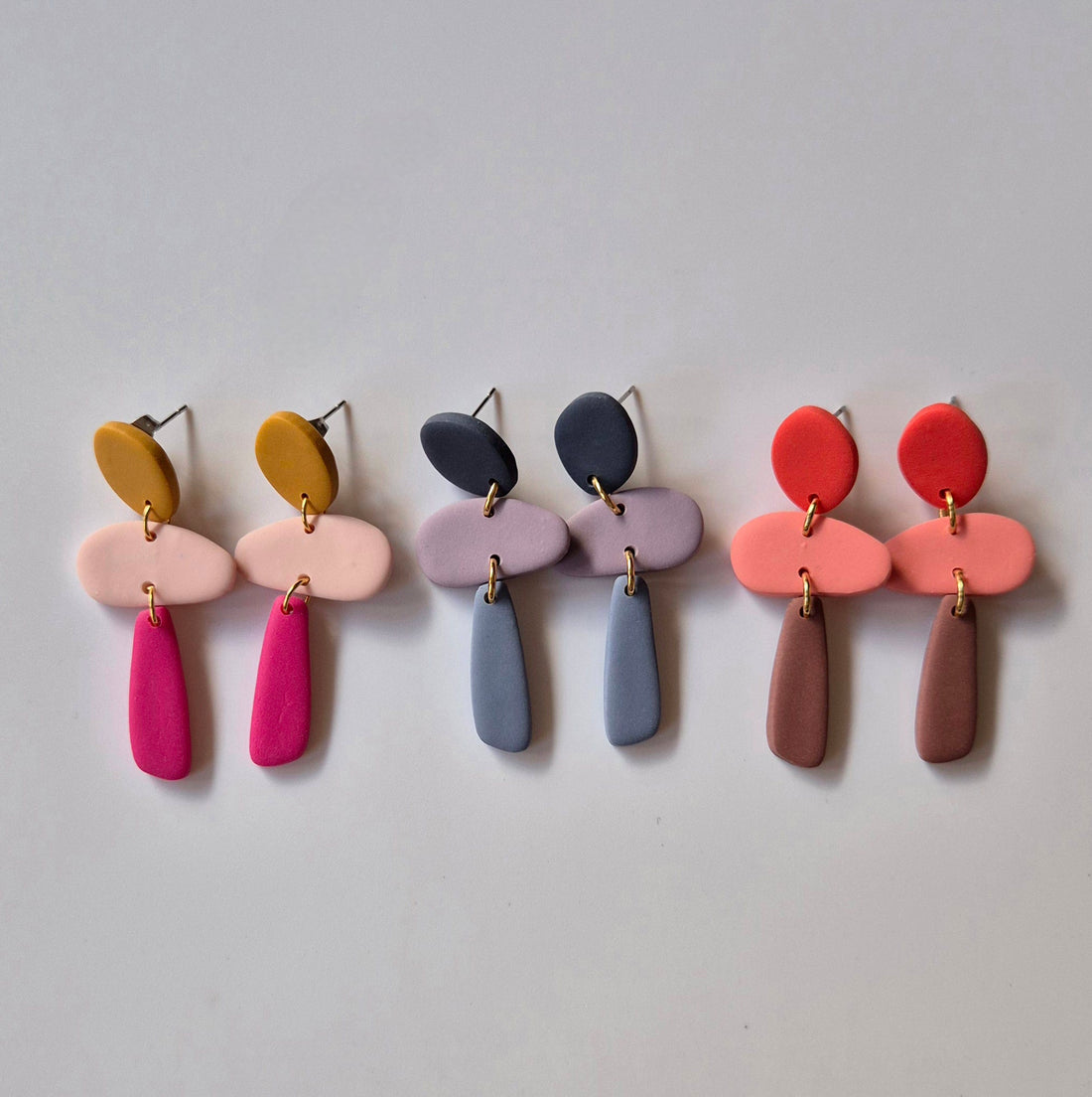 Dreiteilige Ohrringe in organischen Formen, in 3 frühlingshaften Farbvariaten.
Oberes Element sieht aus wie eine abgerundete Raute, mittleres Element erinnert an einen Stein, unterer Teil ist ein längliches Element.